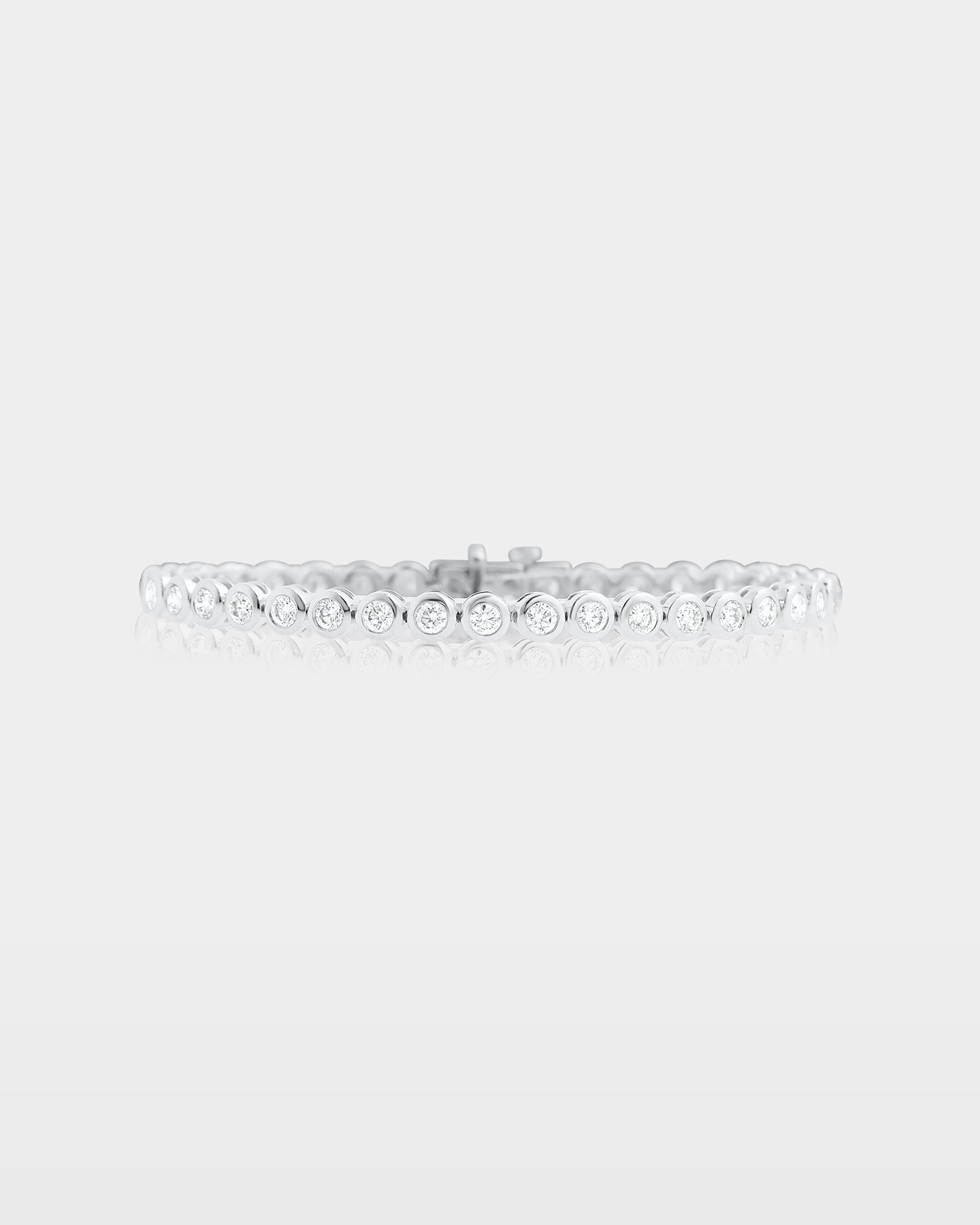 A classic round brilliant diamond tennis bracelet featuring secure individual bezel settings in polished 10k white gold
