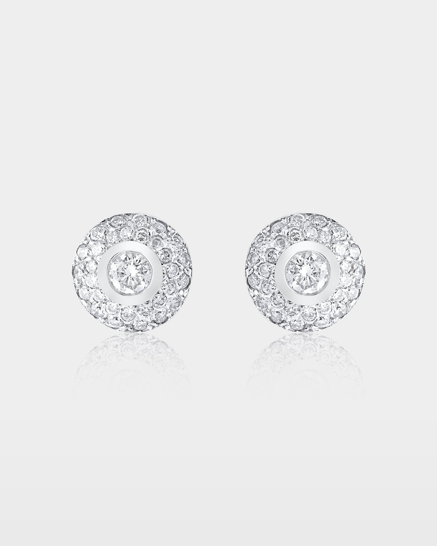 pair of 10k white gold dome stud earrings featuring a center bezel-set diamond surrounded by micro pave diamond rows