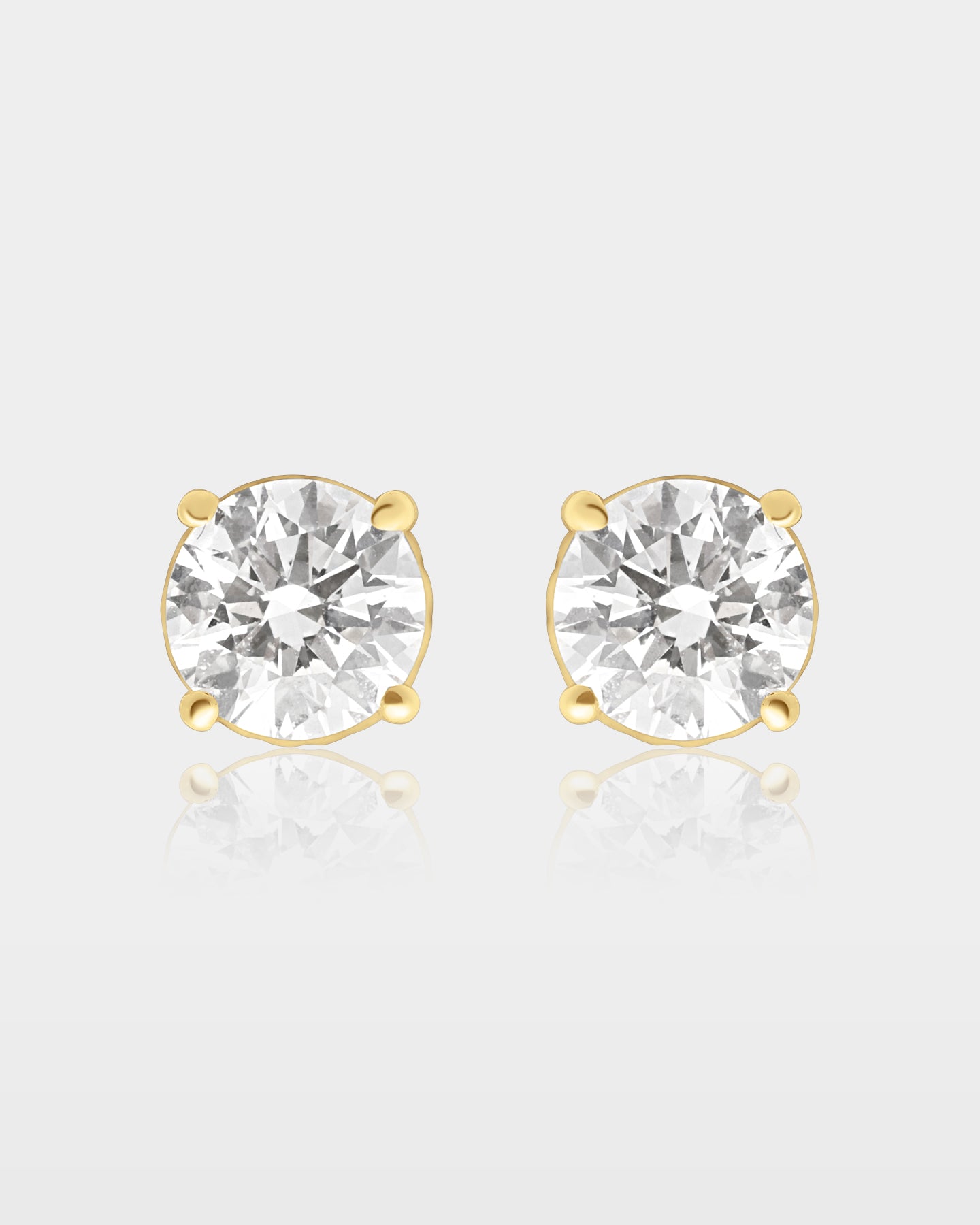 pair of classic round brilliant-cut diamond solitaire stud earrings in a traditional 10k yellow gold four-prong setting