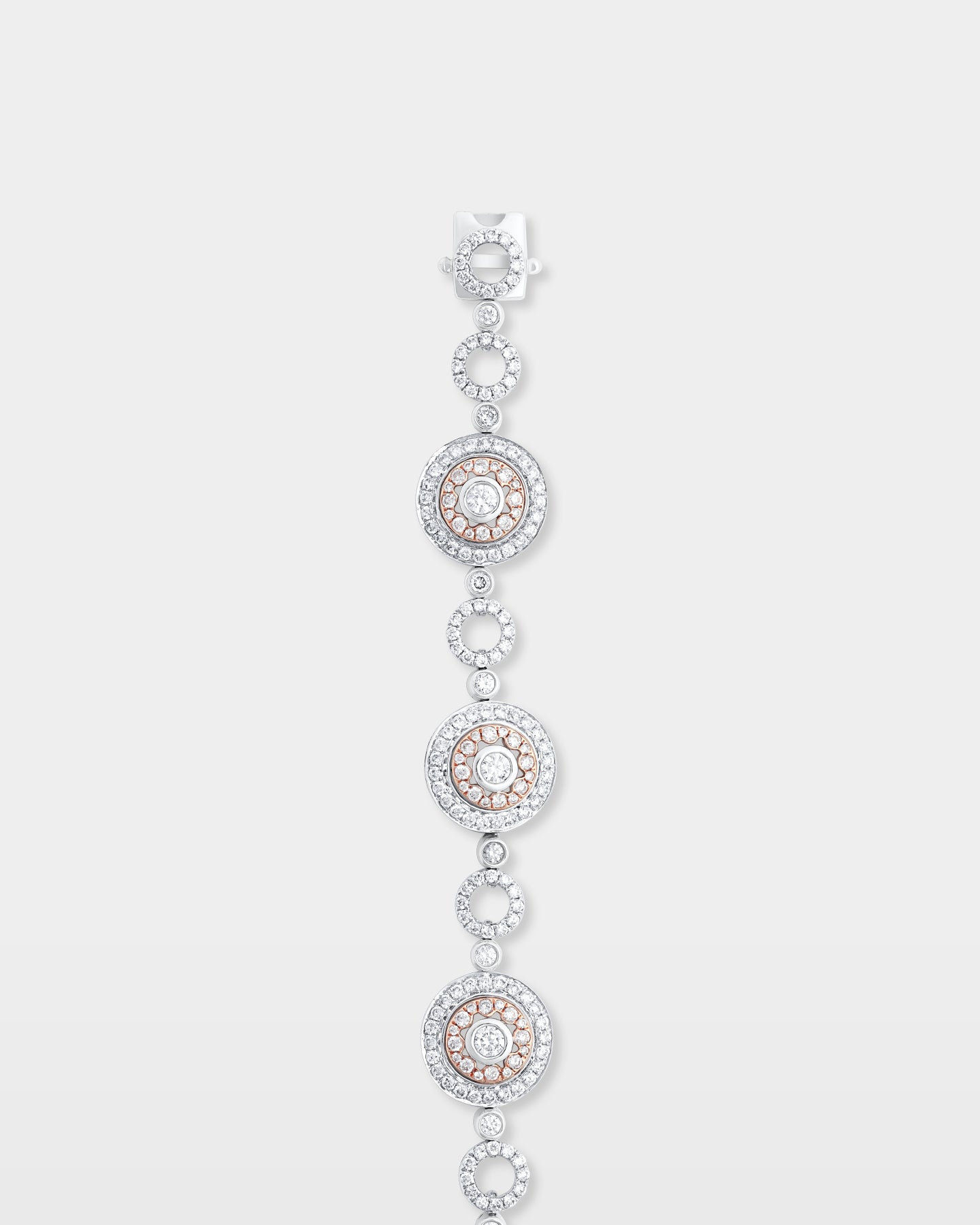A top-down view of an articulated two-tone gold round medallion diamond link bracelet highlighting the integrated secure closure clasp