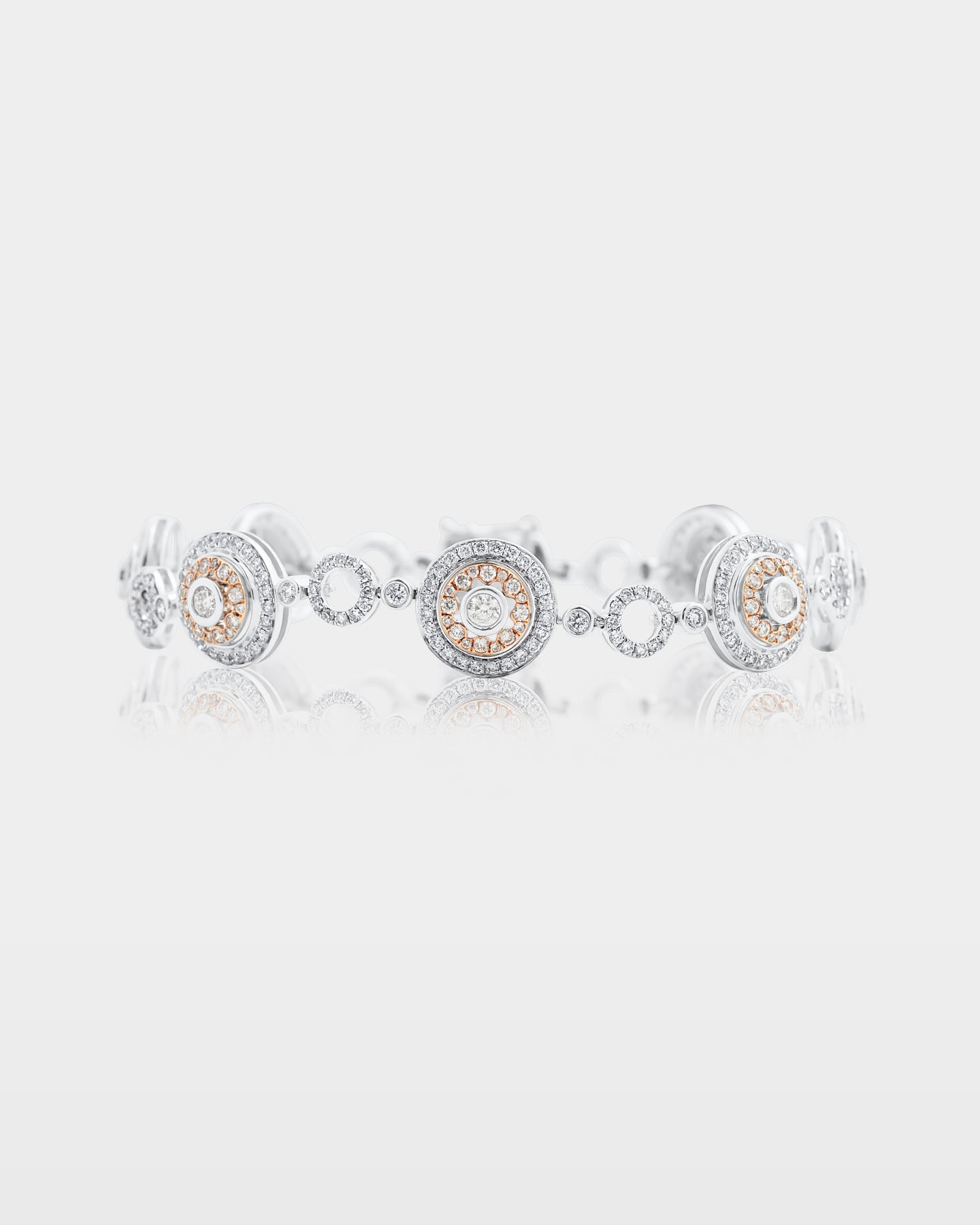 two-tone 14k gold statement bracelet alternating between micro pave diamond open circle links and round rose gold accent medallions