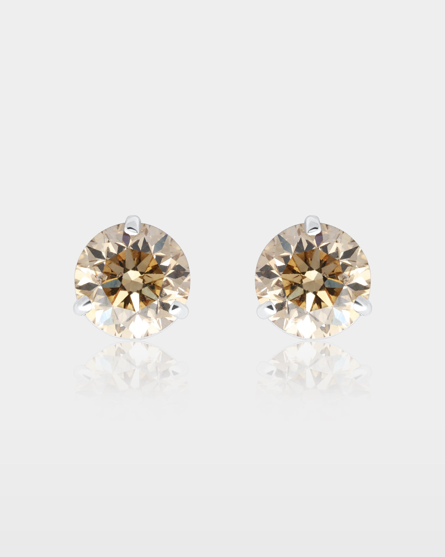 pair of round brilliant-cut champagne diamond solitaire stud earrings in a 14k white gold three-prong martini setting