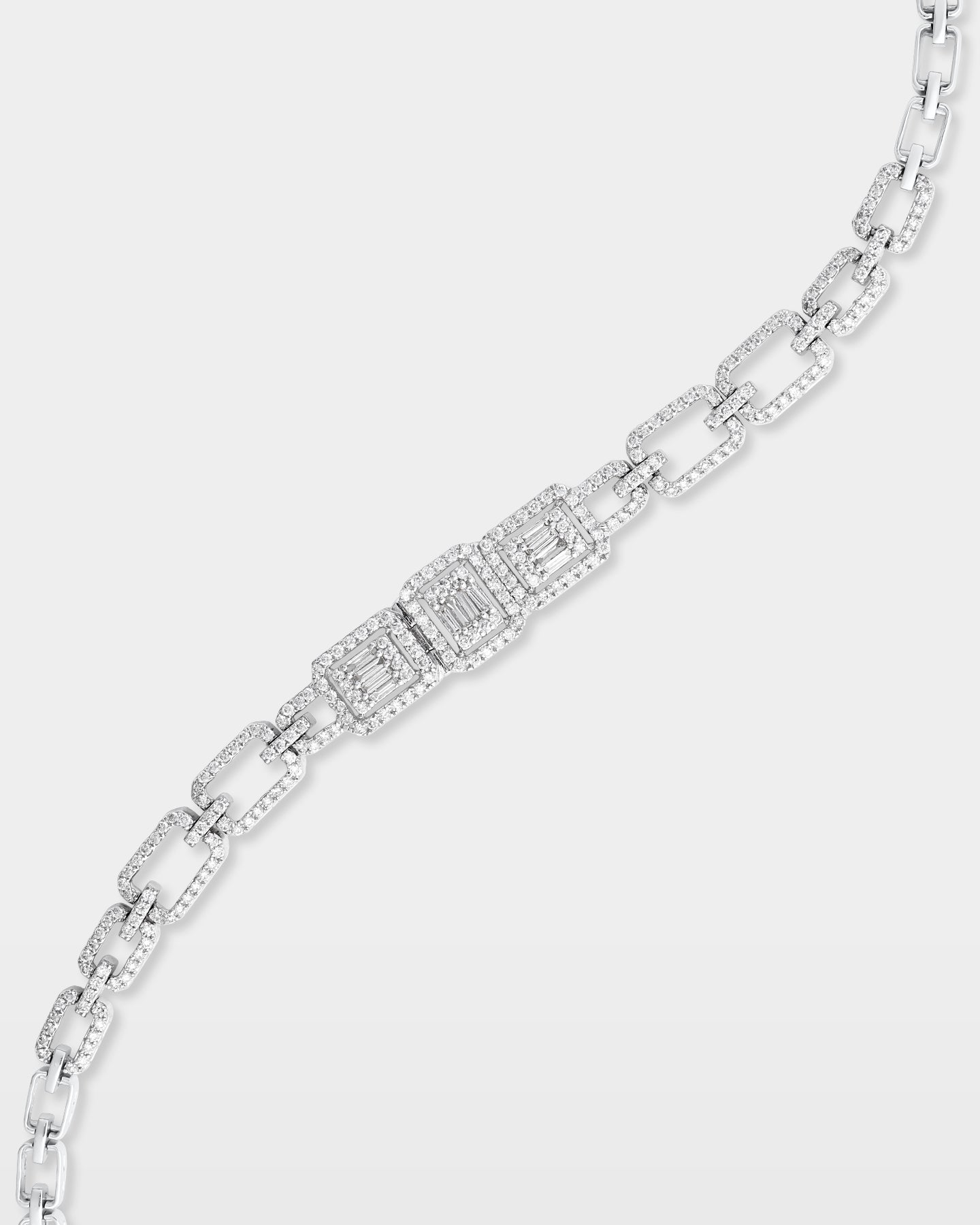 An angled close-up view of an articulated 14k white gold geometric bracelet highlighting the mixed baguette and round diamond settings