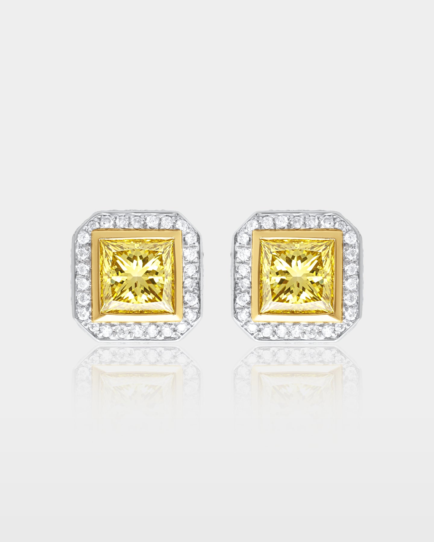 pair of canary yellow princess-cut diamond stud earrings featuring a white gold micro-pave halo and yellow gold center settings
