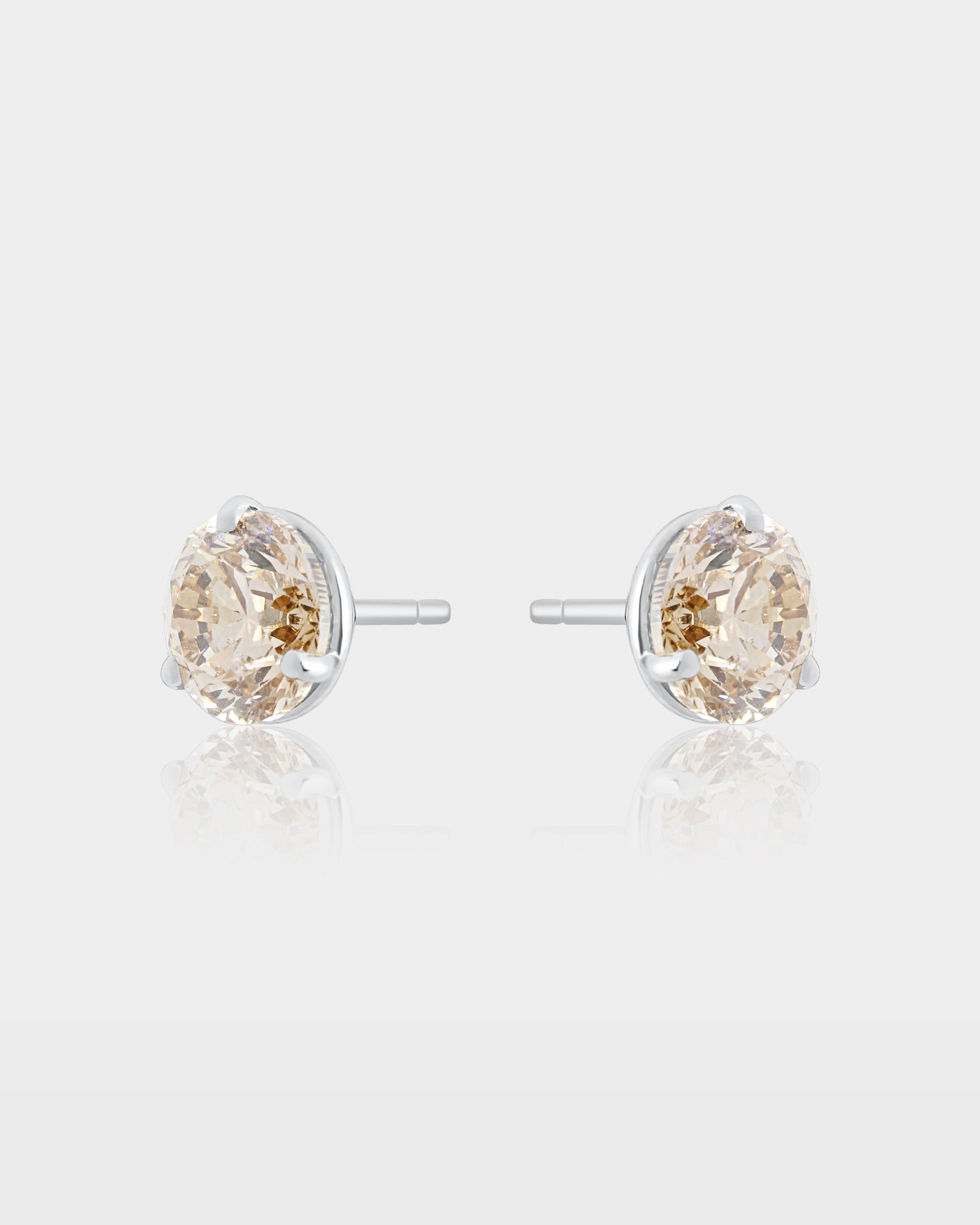 Side and reverse studio view of fancy champagne diamond martini stud earrings showing the white gold posts and low-profile cone settings