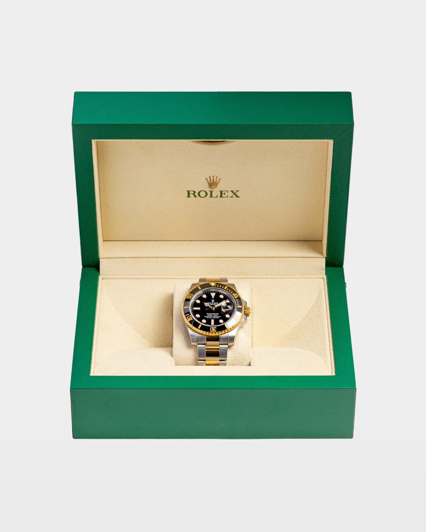 open classic green wave-motif Rolex watch presentation box displaying a two-tone black dial Submariner Date inside