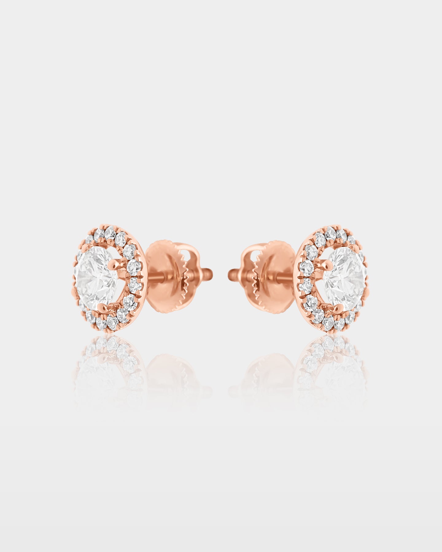 Side and reverse studio profile view of round diamond halo pavé stud earrings showing the 10k rose gold posts and secure screw backings