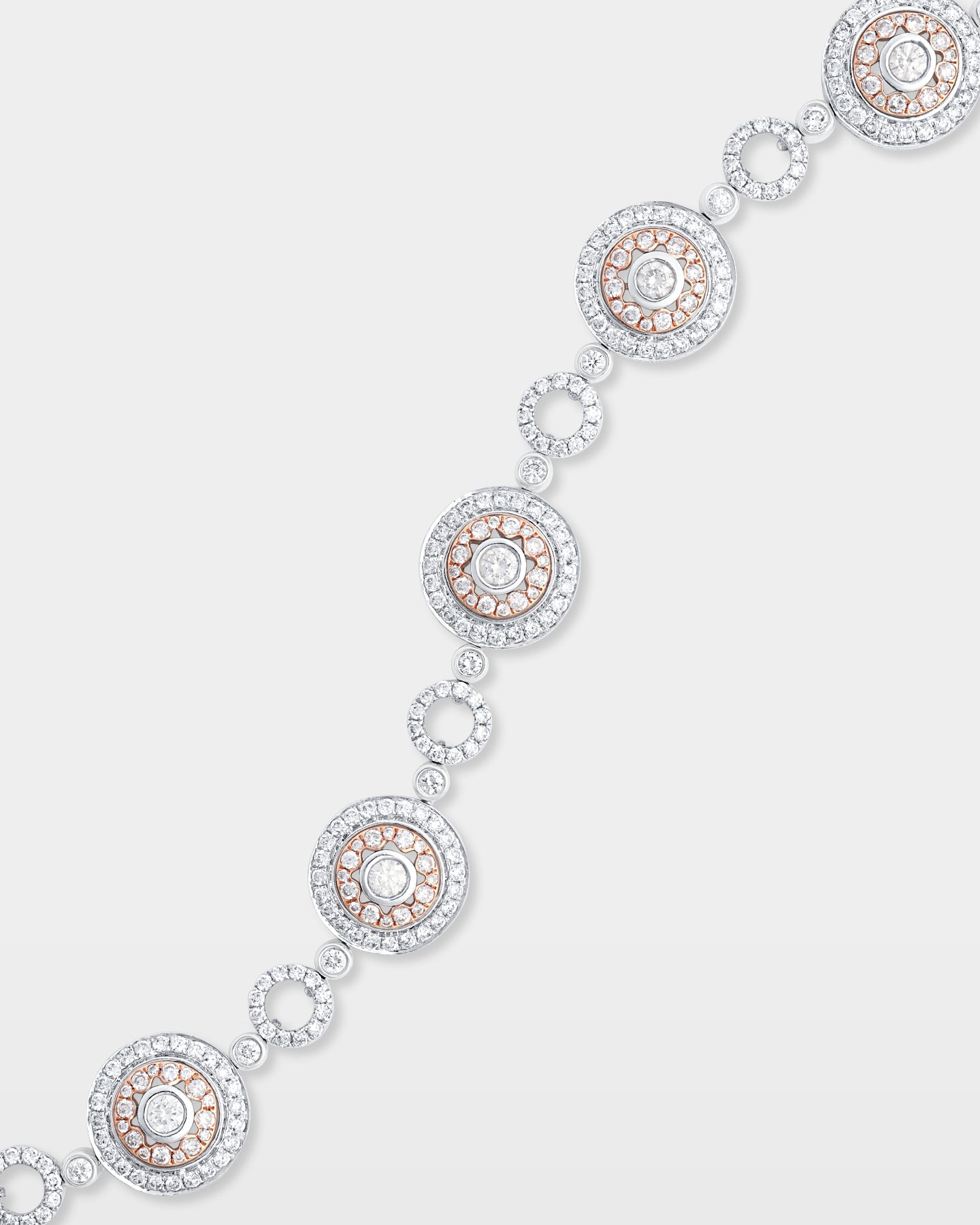 Close-up studio view showcasing the fluid link articulation and detailed white and rose gold concentric metalwork of a diamond circle bracelet